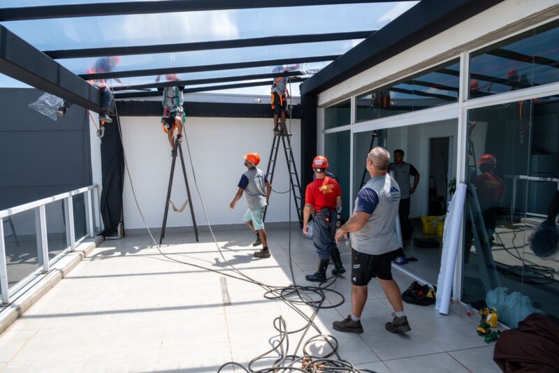 Equipe de montagem e bombeiro civil instalando o pergolado do terraço