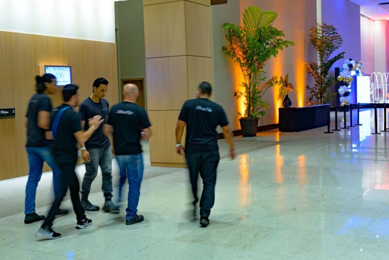 Equipe da BlueTie atravessando o foyer durante a Festa do Centenário da SMCC