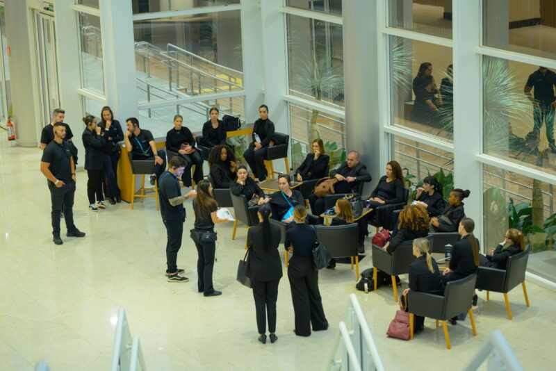 Equipe da BlueTie reunida no foyer envidraçado antes da Festa do Centenário da SMCC
