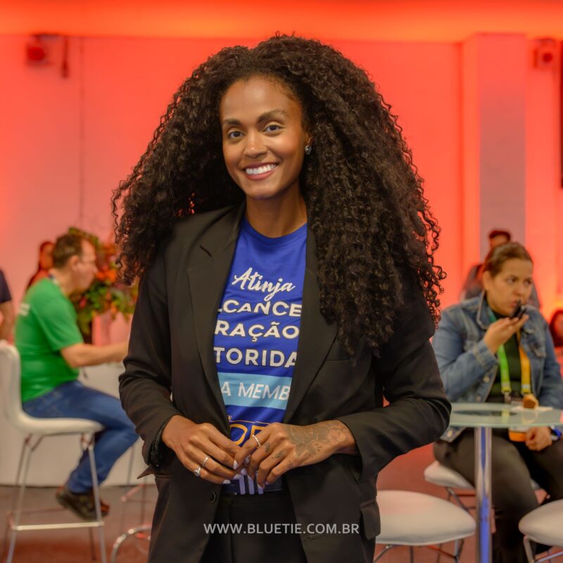 Participante sorrindo em um estande durante o ERP Summit